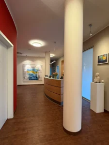 Moderner Empfangsbereich der Orthopädischen Prvatpraxis Bernau am Chiemsee in Harmonie mit Kunstwerken von Uta Beckert
